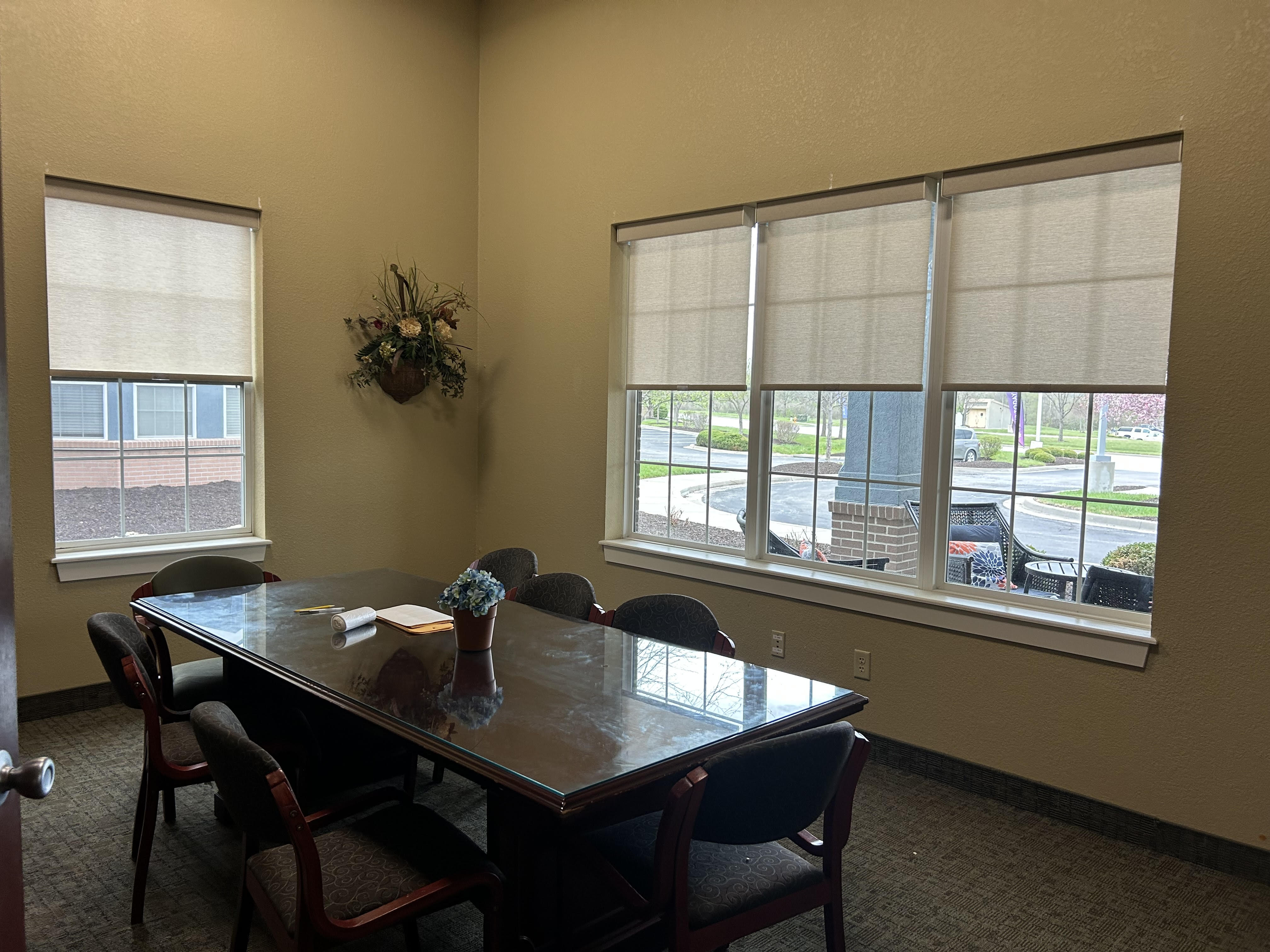 Roller shades in four windows inside country club