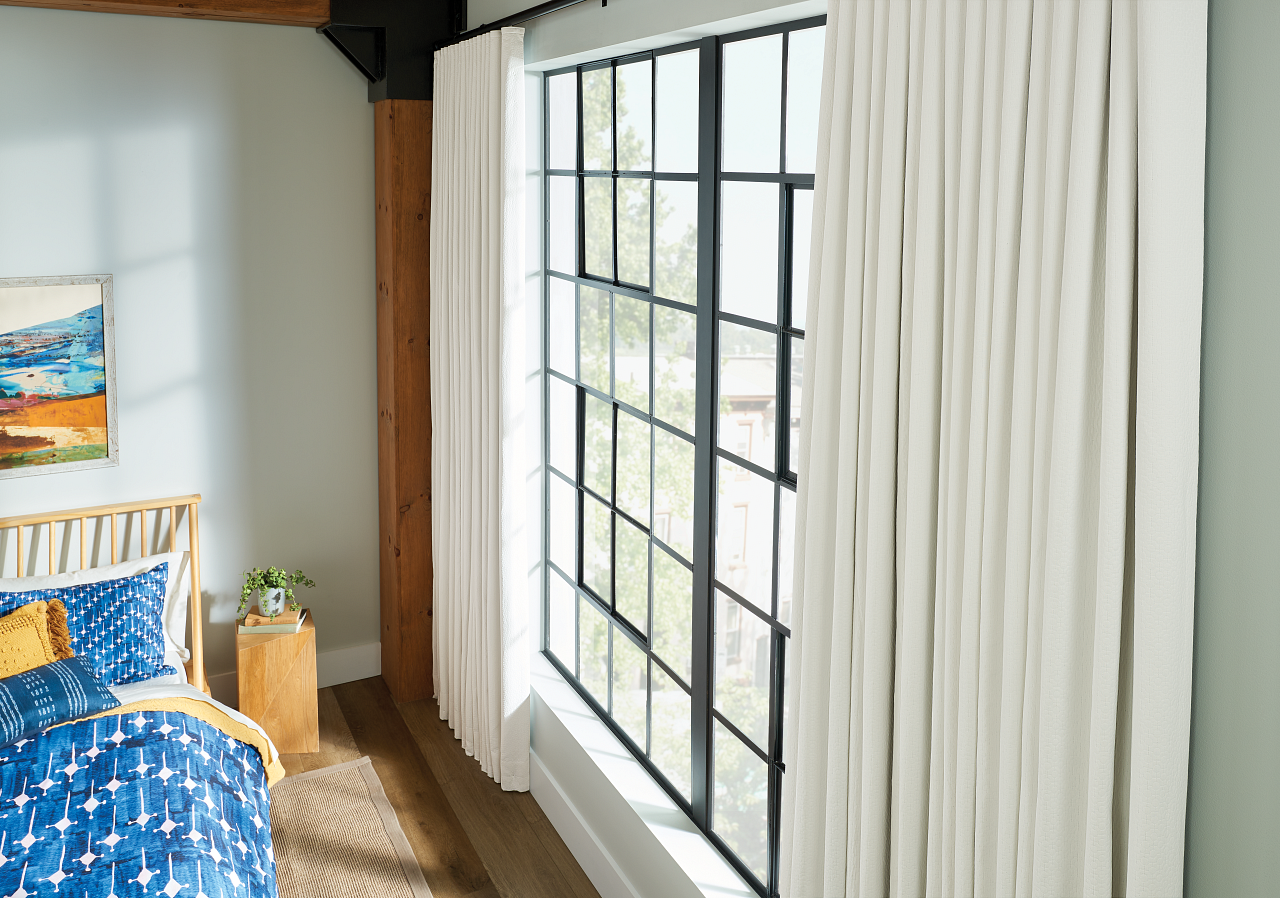Elegant white draperies framing a large beautiful bedroom window