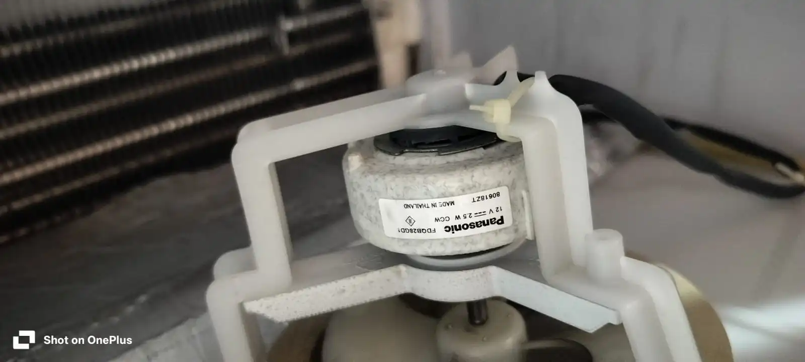 Close-up of a replacement fan motor with the model number visible