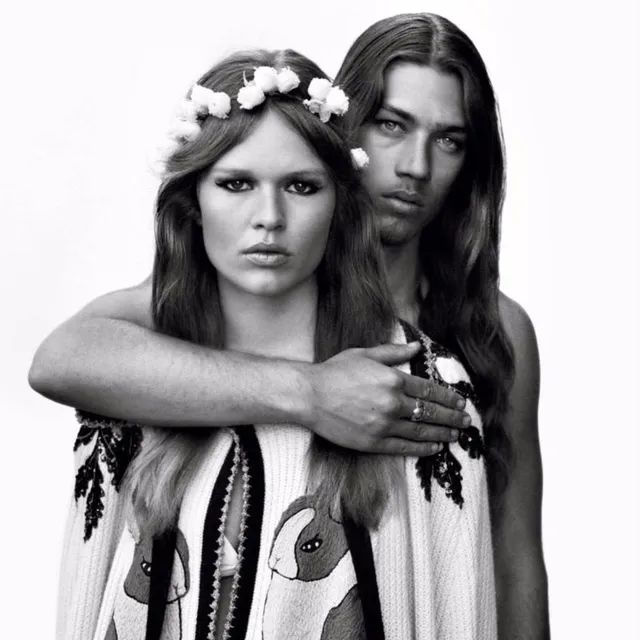 Un couple riant et discutant dans un bar chic, symbolisant la joie des rencontres authentiques hors ligne.