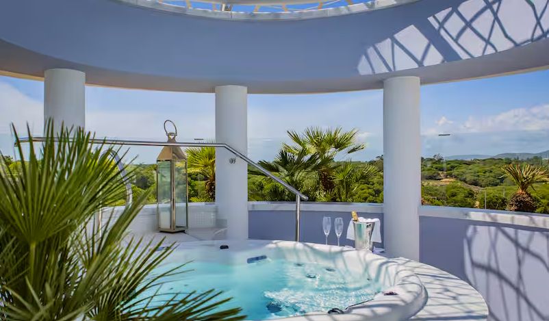 Un intérieur élégant et moderne d'une suite Hilton de luxe, avec vue sur l'océan, mobilier design et une palette de couleurs apaisante.