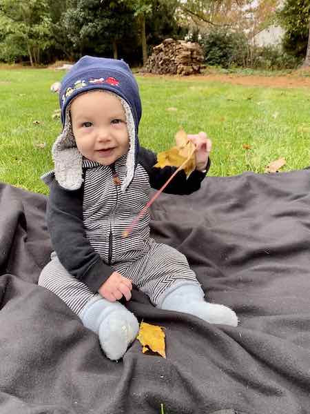 baby sitting on travel blanket