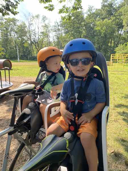 Toddler Boy on bike carrier at the park