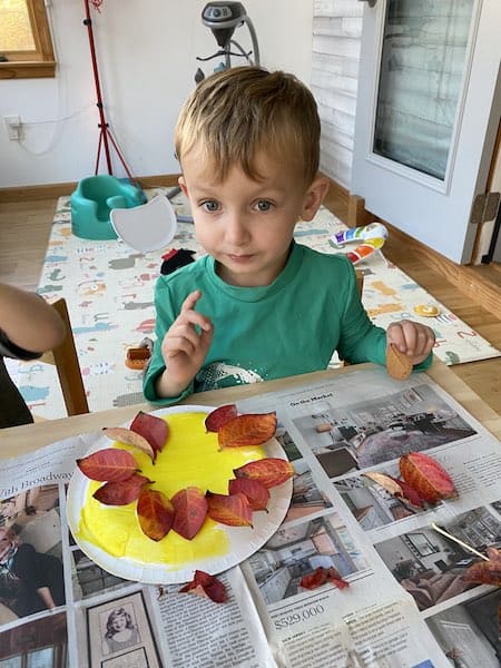 preschooler and toddler nature craft lion mane being glued on