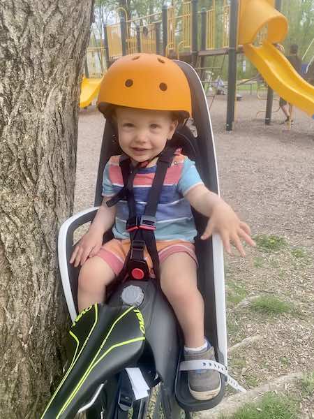 Toddler on bike with back bike carrier