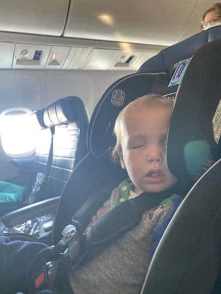 toddler sleeping in carseat on airplane