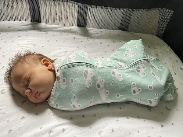 newborn daughter in woombie swaddle