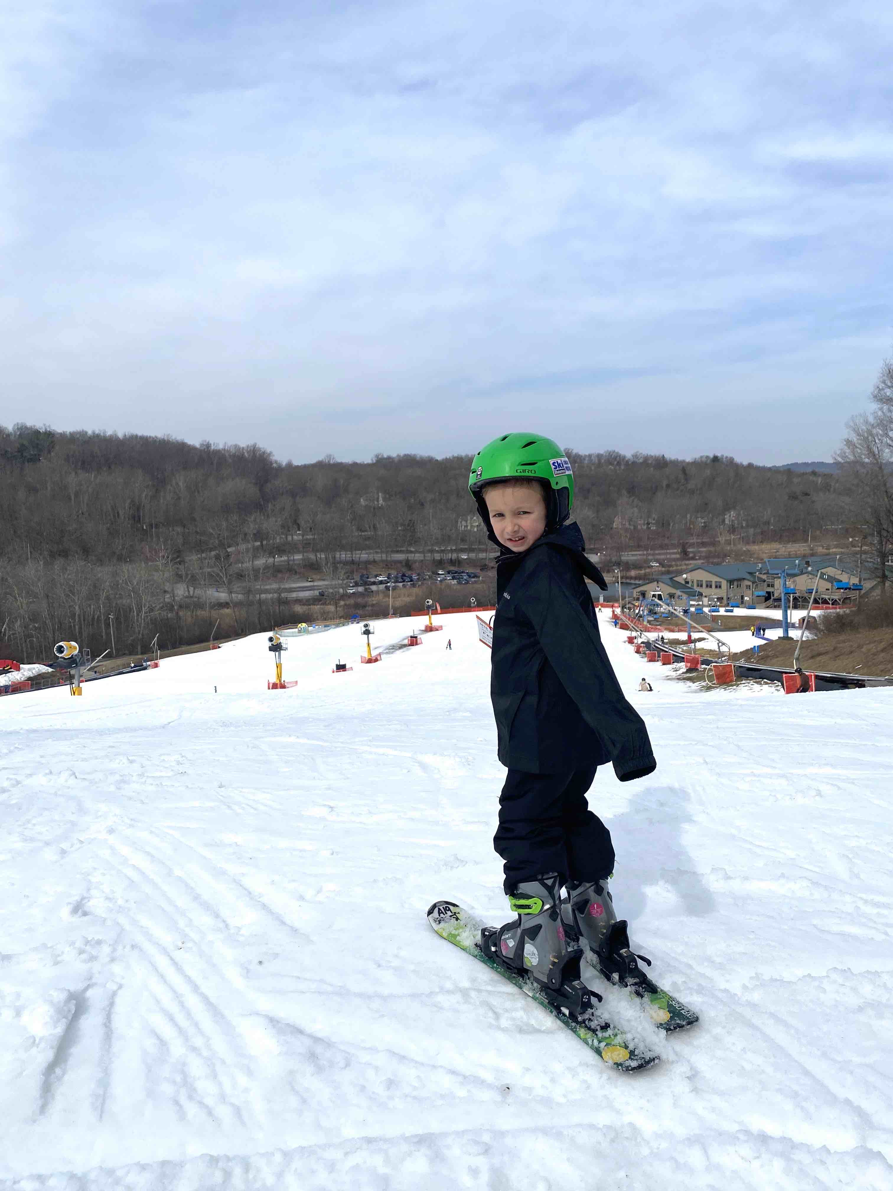 5 year old kid at top of ski hill