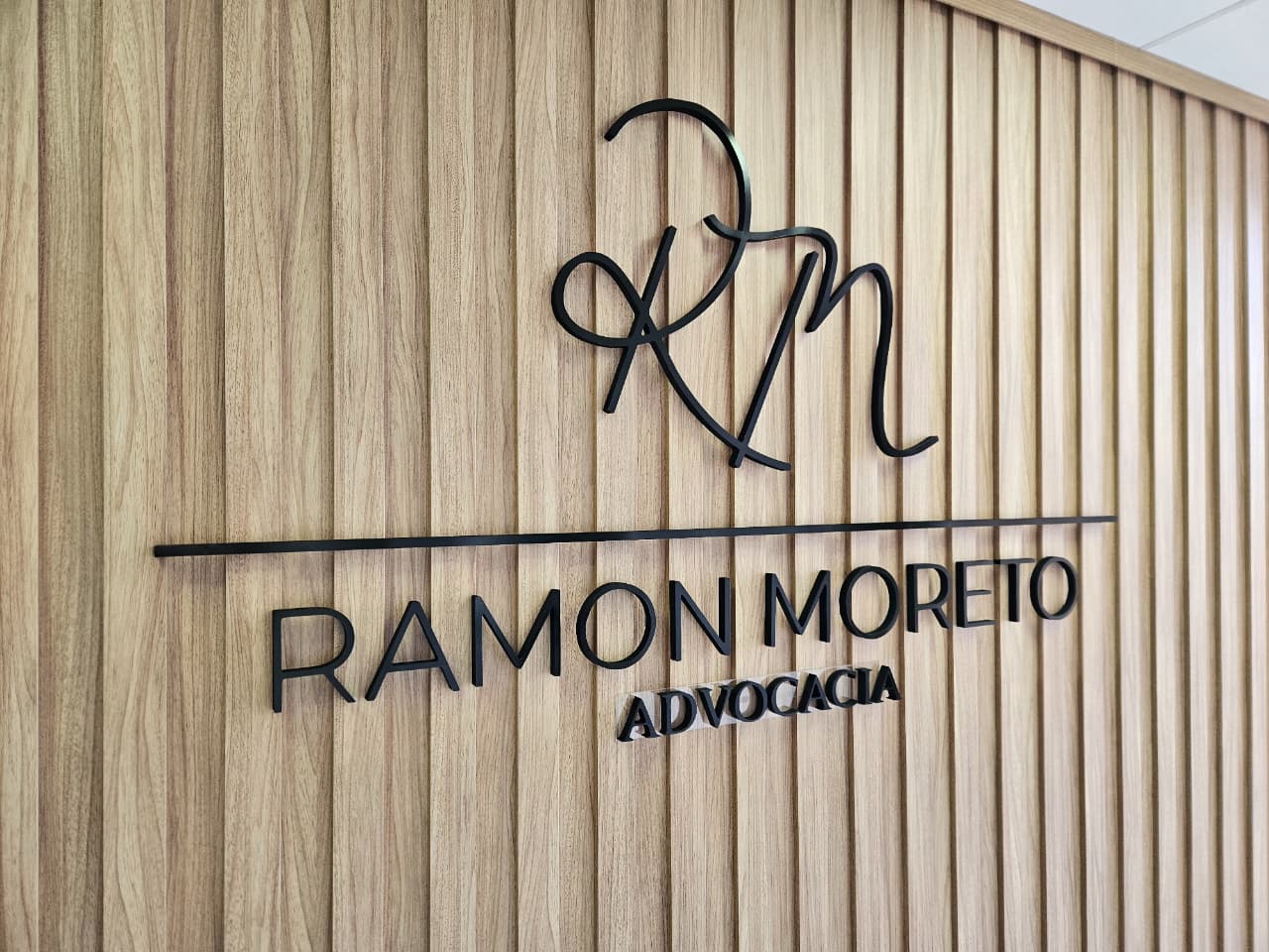 Close-up de mãos masculinas assinando documento legal importante em mesa de escritório com caneta preta, representando serviços jurídicos profissionais