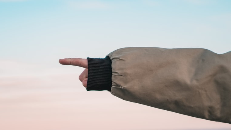 Someone pointing a finger off towards the distance / empty space