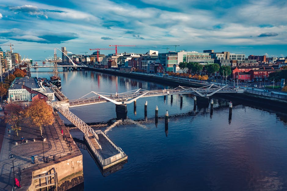 A stylized illustration showing a bridge connecting a futuristic city (representing technology and business) to a serene natural landscape (representing well-being and ethics), under a sky transitioning from day to night. Illustrative, 16:9 aspect ratio. - Photo by Luciann Photography on Pexels