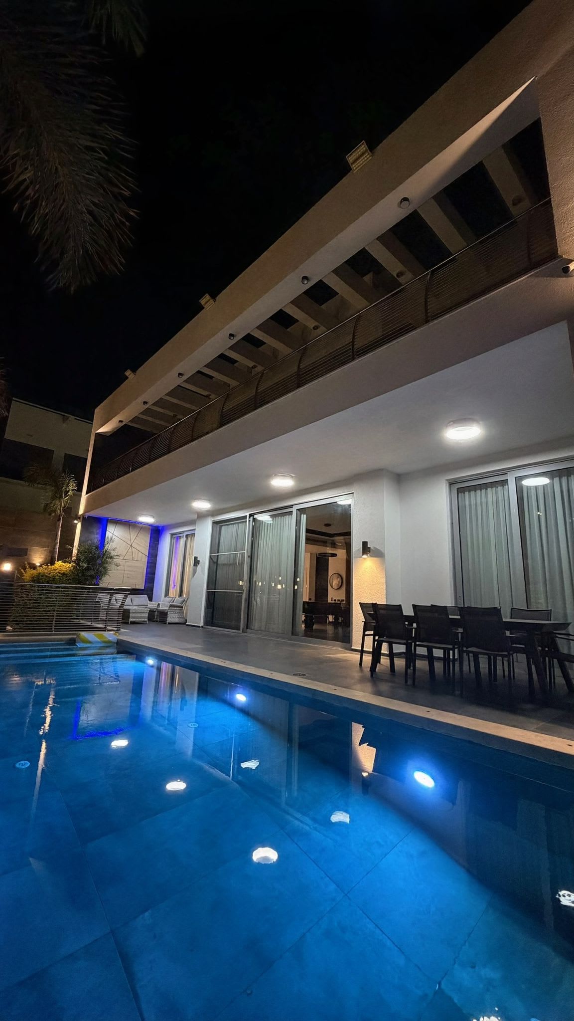 Piscine privée éclairée la nuit dans le jardin d'une villa à louer dans le centre d'Eilat