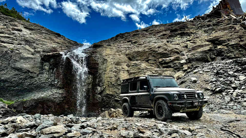 4x4 off-road vehicle with Reiger suspension in rocky terrain near a waterfall