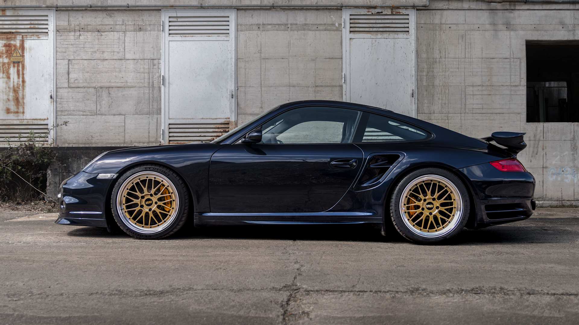 Side view of a black Porsche 911 997 with coilovers by KW