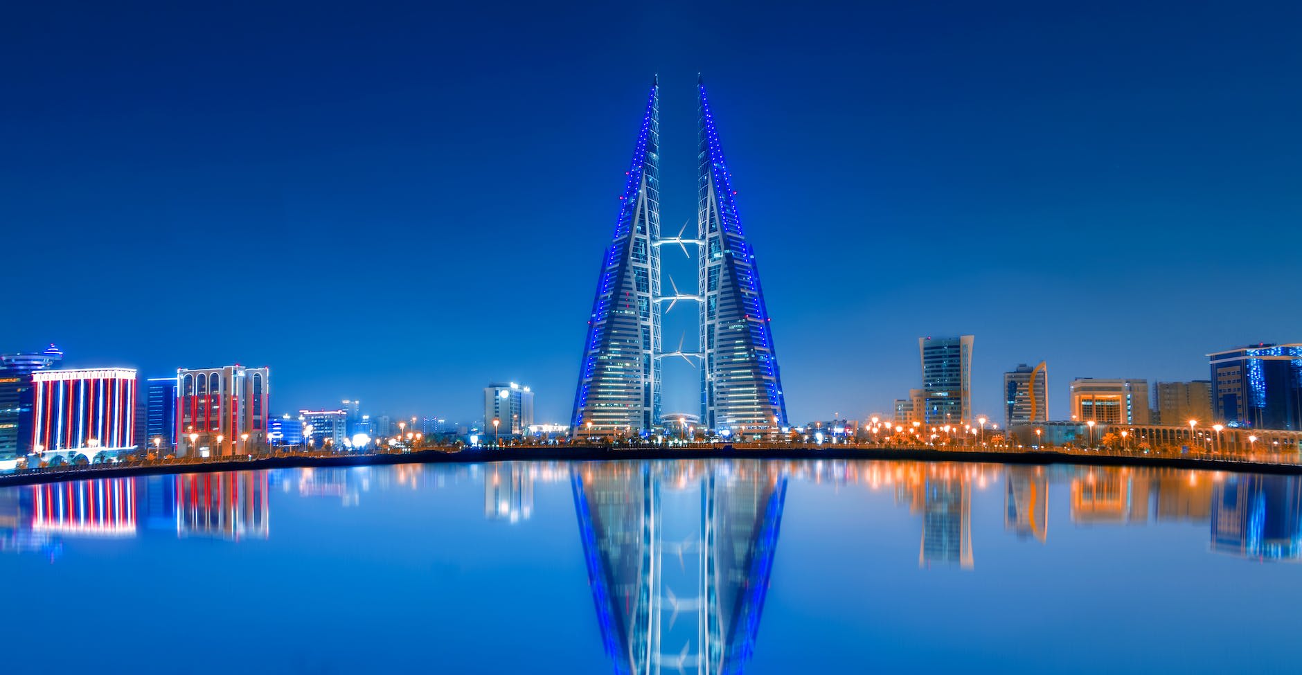 Explore Bahrain: Unforgettable Travel Experiences During Your 2023 Formula One Trip - SMET Bahrain blue and purple lighted tower near body of water during night time