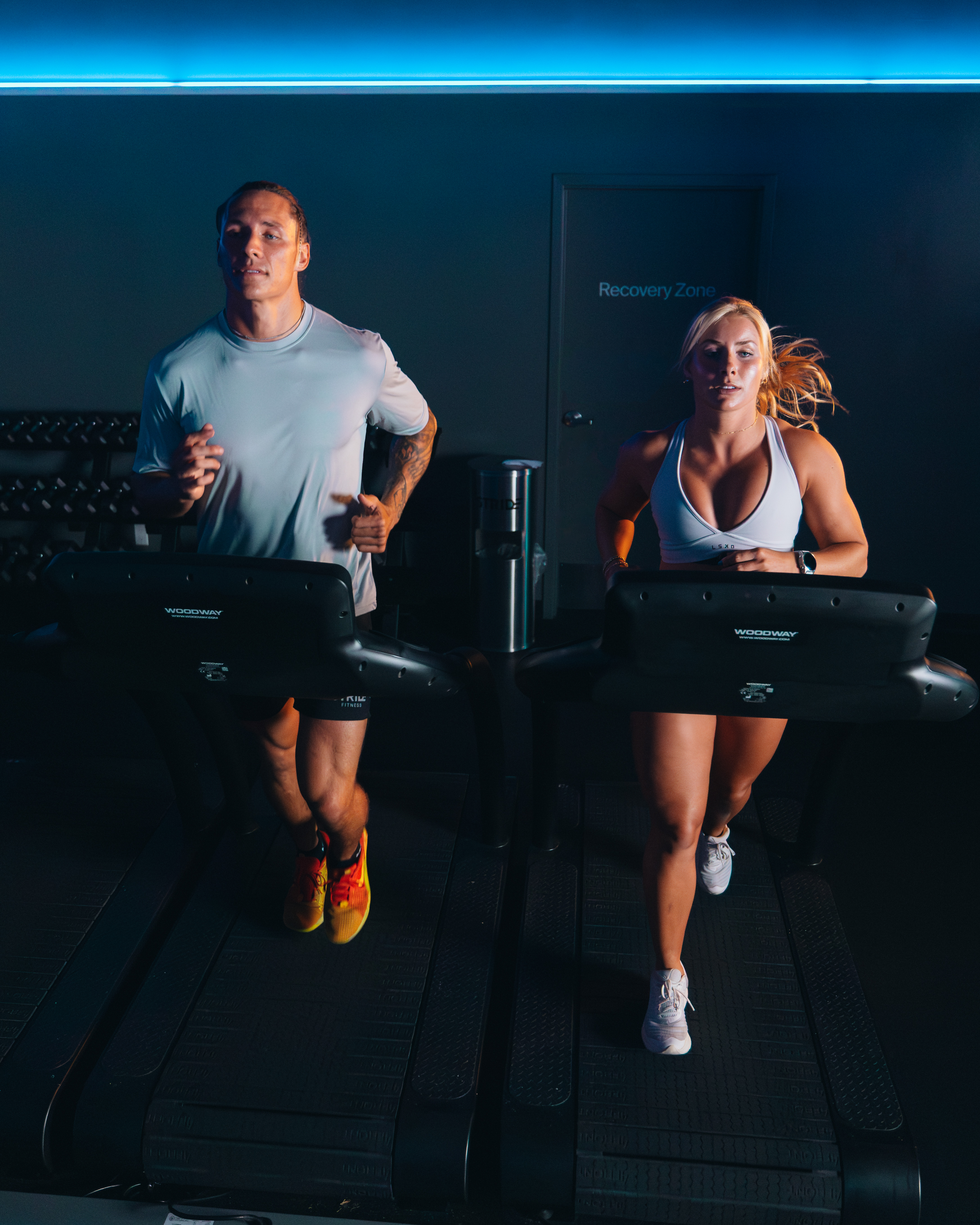 STRIDE Fitness members walking, jogging, and running together on Woodway treadmills during a group fitness class
