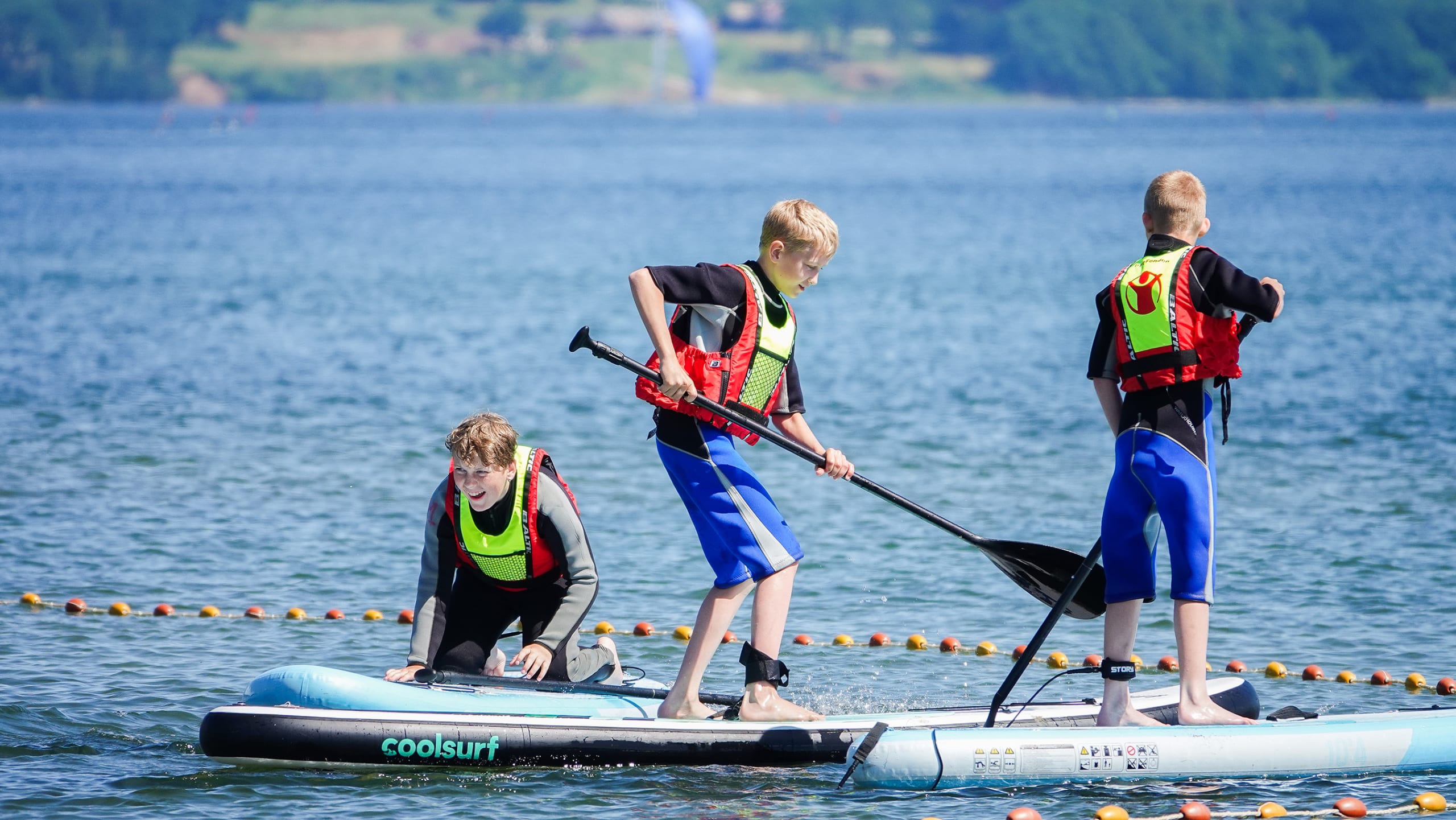 Tre børn på paddleboards