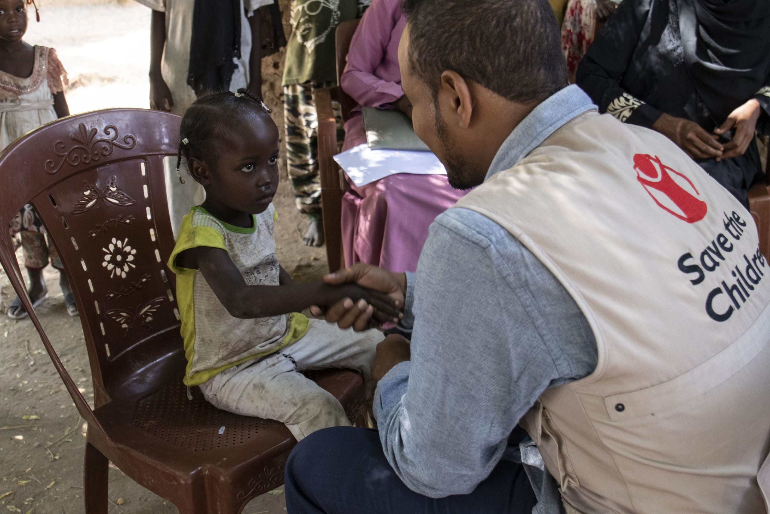 Vaccinationslægen, Mohamed, beroliger en lille pige inden hun skal vaccineres mod kolera.