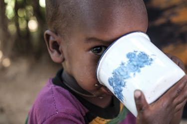 Lille Abdi kigger undrende i kameraet mens han drikker sin mælk