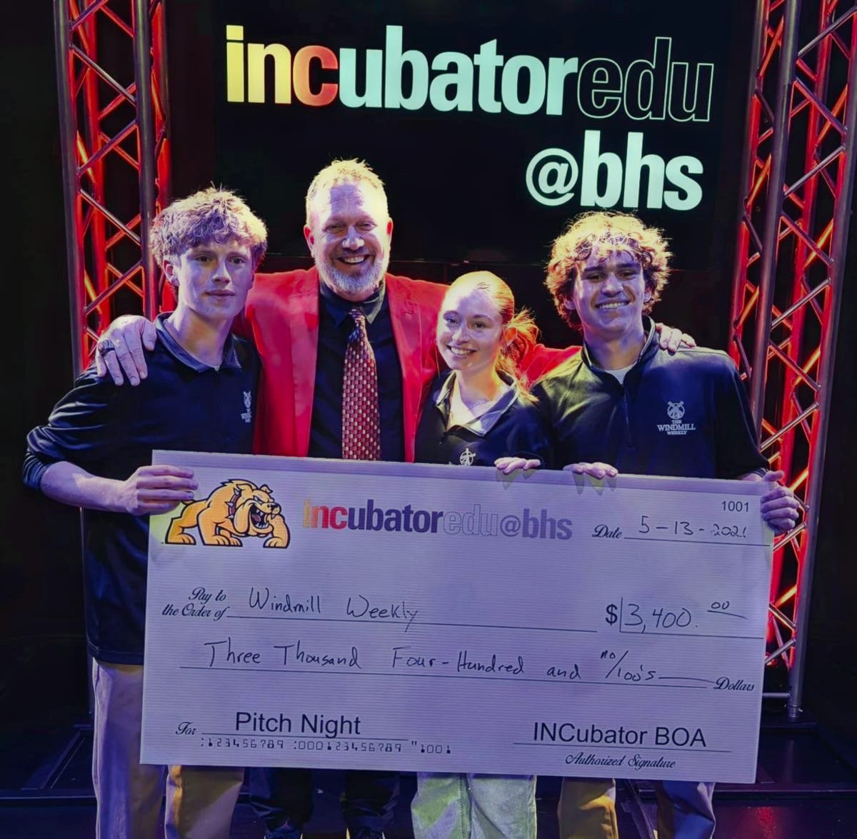 Dennis Piron with Batavia High School students Ben Manikas, Lexie Kammes and Bryan Wnek, holding a $3,400 check awarded to The Windmill Weekly at INCubator Pitch Night