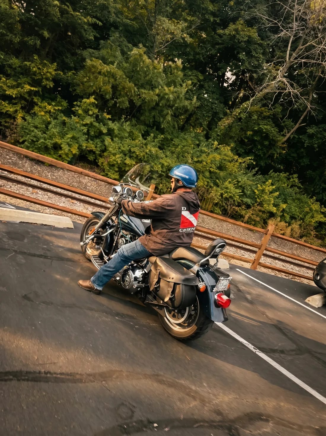 Brent Allen riding his Harley-Davidson away down a tree-lined road