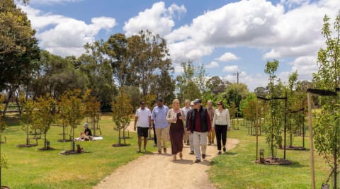 A group of visitors walking along a garden path at a Mornington Green open day.
