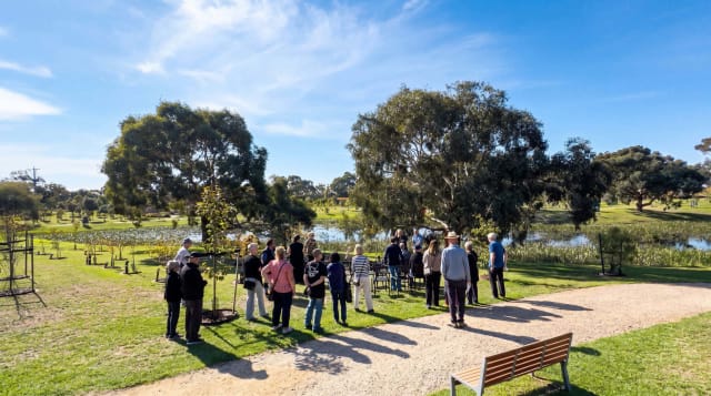 Visitors gathered in the garden by the lake during a Mornington Green open day.