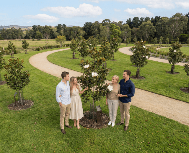 A family of four gathered around their magnolia memorial tree at Mornington Green.
