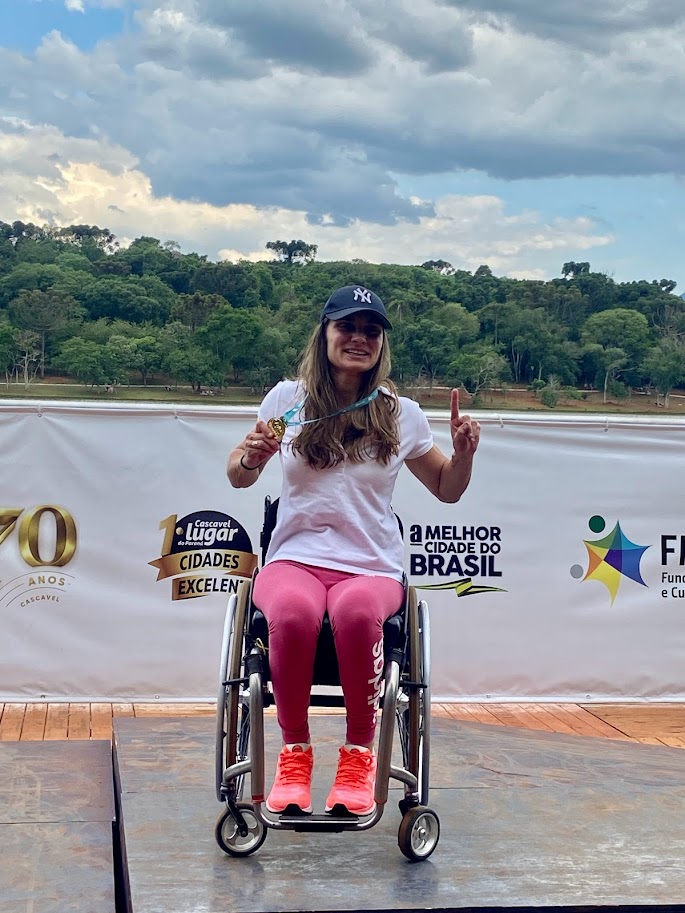 Andréa Pontes em pódio segurando medalha