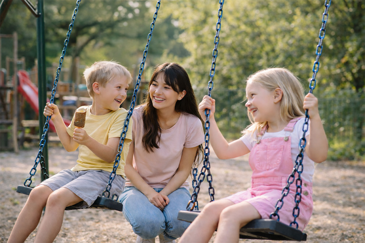 Au-pair mit Kindern auf dem Spielplatz