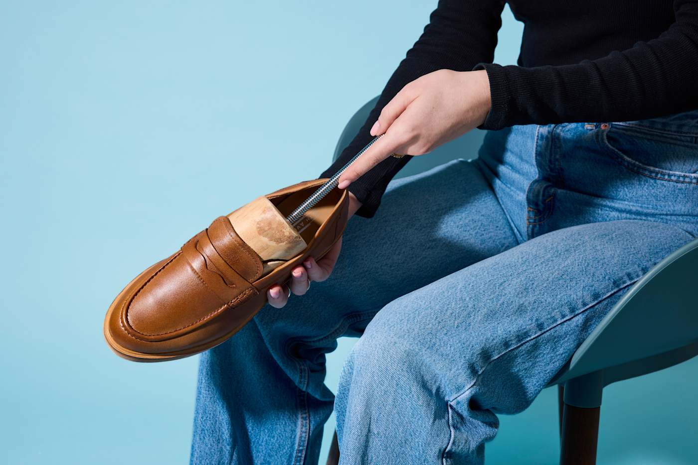 Una persona allarga le scarpe con un allargascarpe