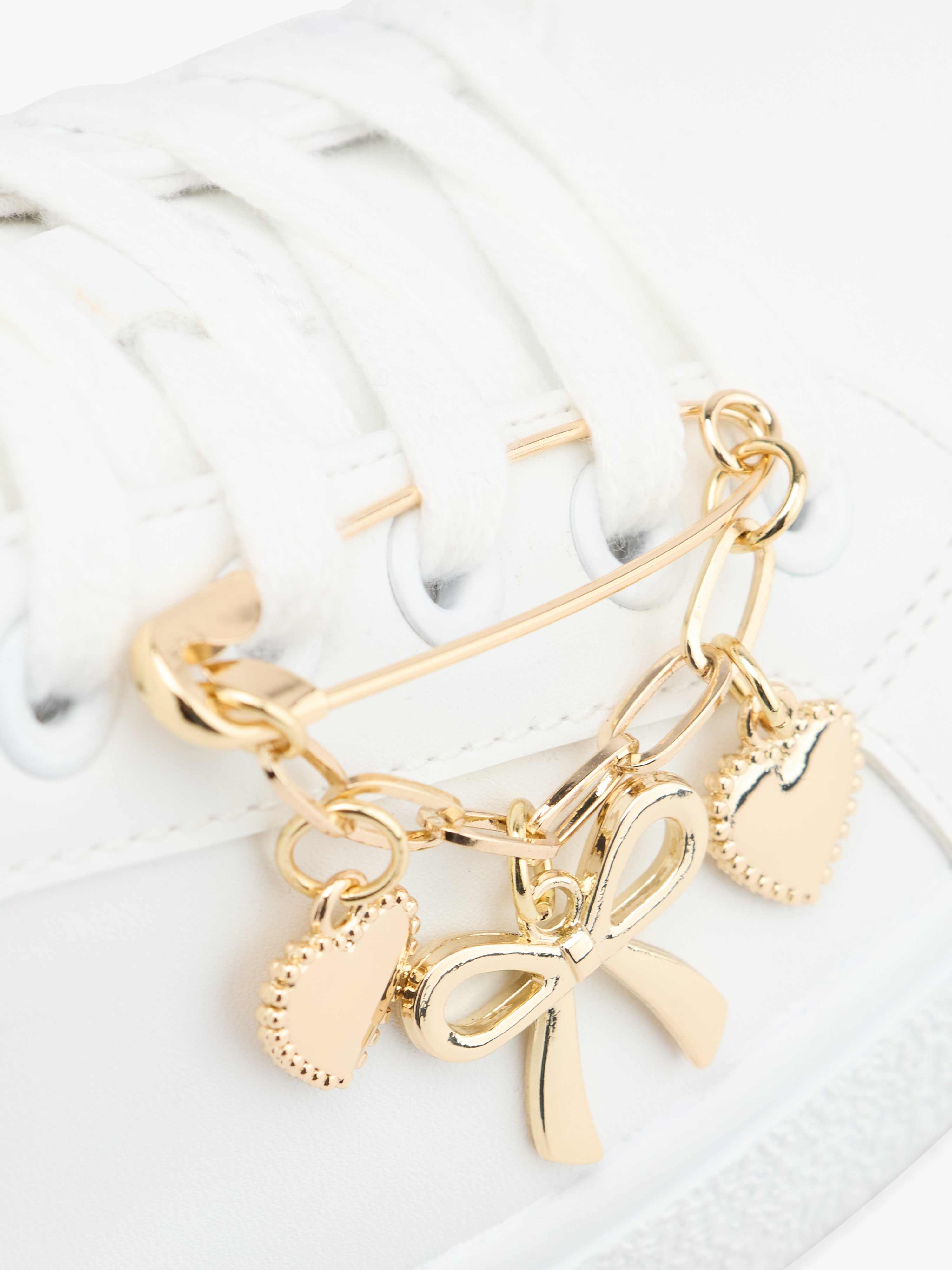 Weiße Lederschuhe mit goldener Kette, Herzanhängern und Schleife