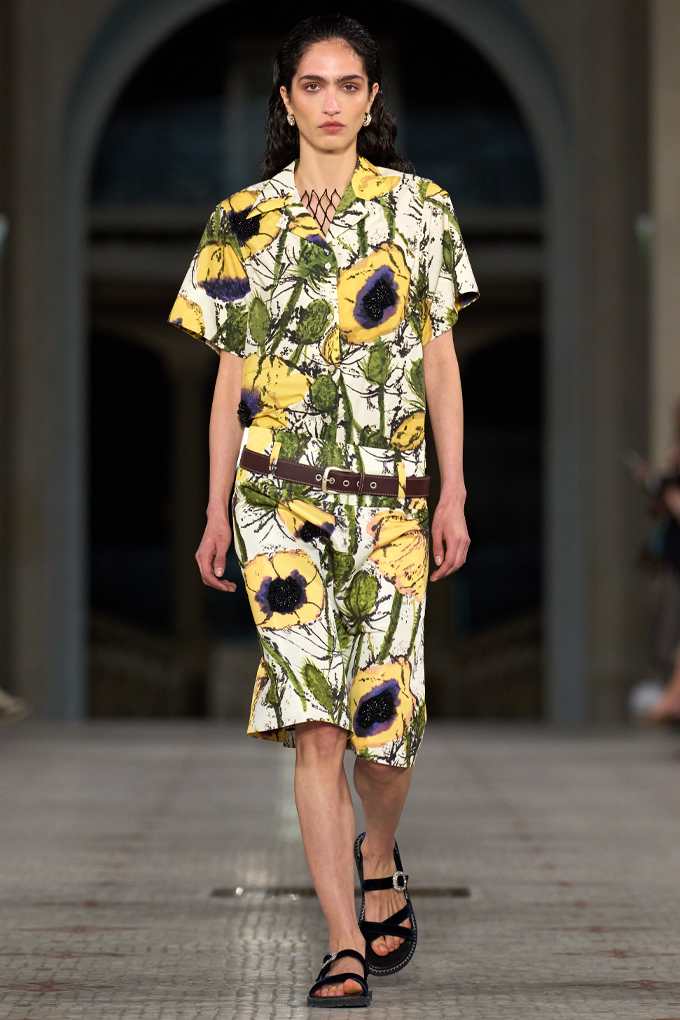 Frau in bunt-floral gemustertem Kleid, kombiniert mit robusten Trekking-Sandalen