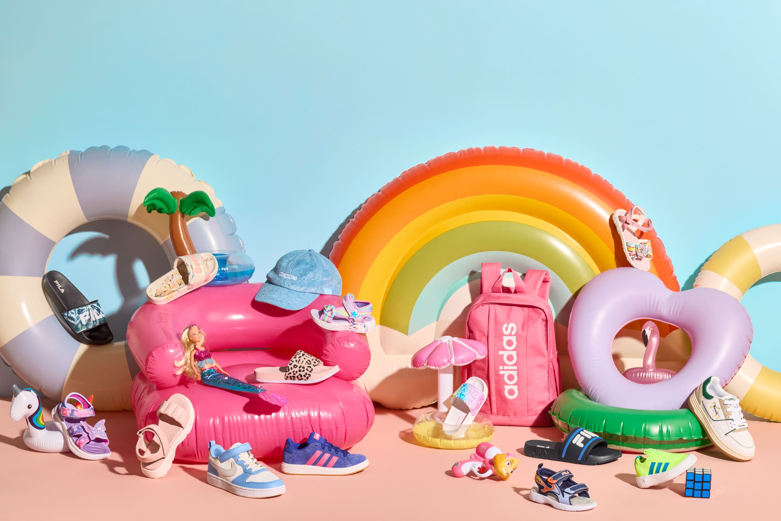 Bunte Ansammlung von Kinderschuhen und aufblasbarem Strand-Spielzeug