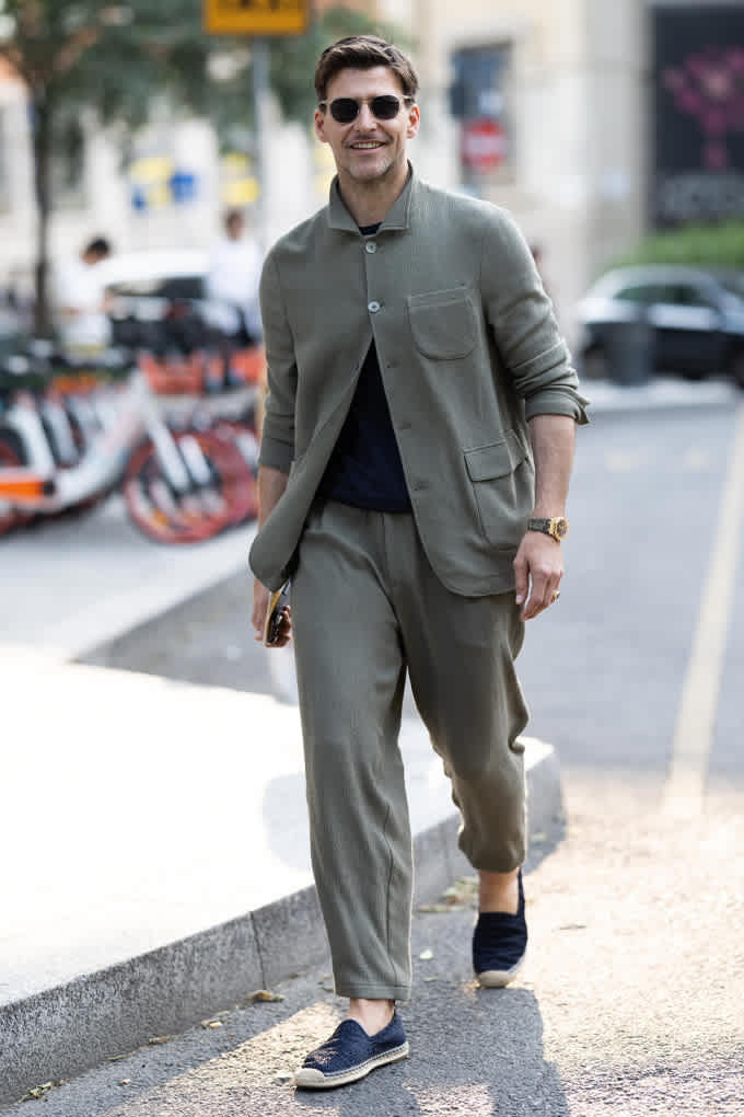 Mann in lässigem Monochrome-Look trägt Espadrilles bei Spaziergang