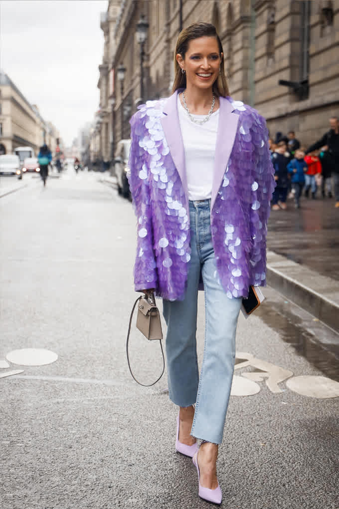 Eine Frau mit kühlem Farbtyp trägt einen palliettenbesetzen Statement-Blazer in frischem Lila