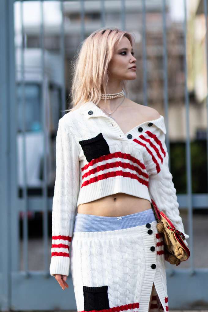 Blonde Frau mit gestricktem Cropped-Sweater in Rot-Weiß