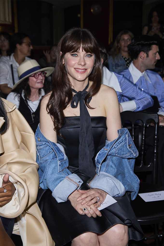 Schauspielerin Zooey Deschanel nimmt in schwarzem Kleid mit Jeansjacke an Fashion Week teil