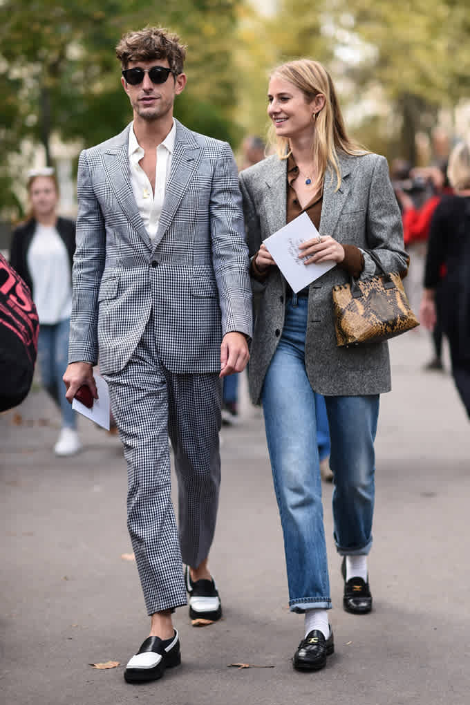 Un uomo e una donna passeggiano fianco a fianco in look preppy