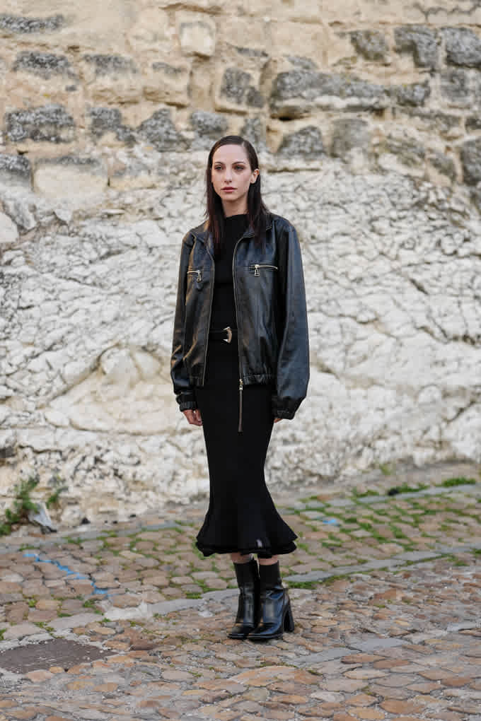 Frau in schwarzer Lederjacke mit Strick-Hose und passenden Ankle Boots