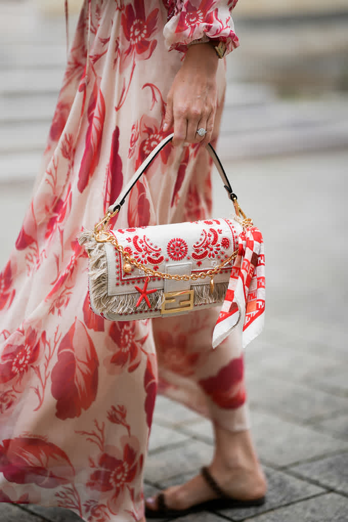 Frau trägt Kleid mit floralen Prints, kombiniert mit passender Handtasche