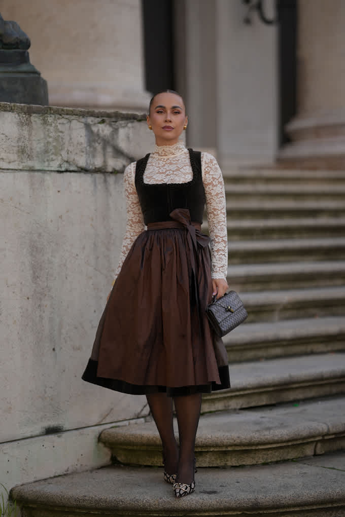 Frau trägt braune Bluse mit Spitze, steht auf Treppe