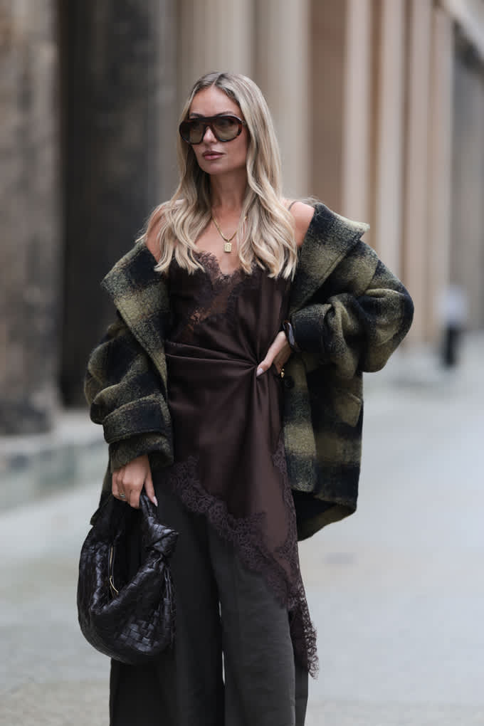 Blonde Frau trägt Slipdress und karierte Oversize Jacke