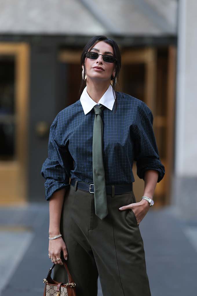 Frau in Preppy Look, trägt Karohemd mit XXL-Kragen und Krawatte