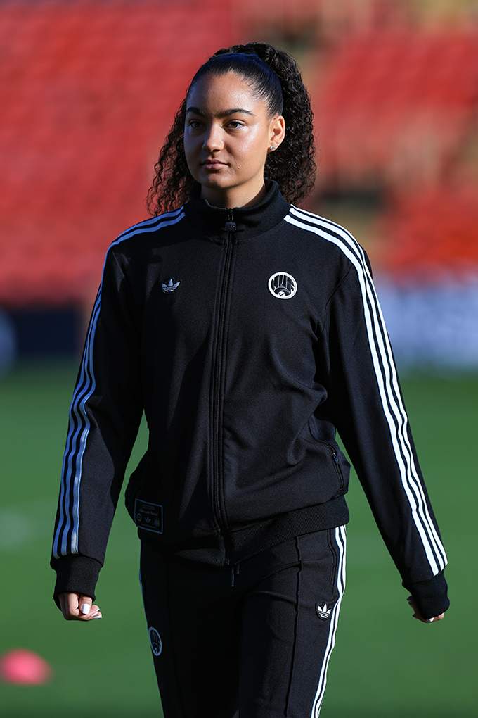 Frau in schwarzem Sport-Trainingsanzug der Marke adidas