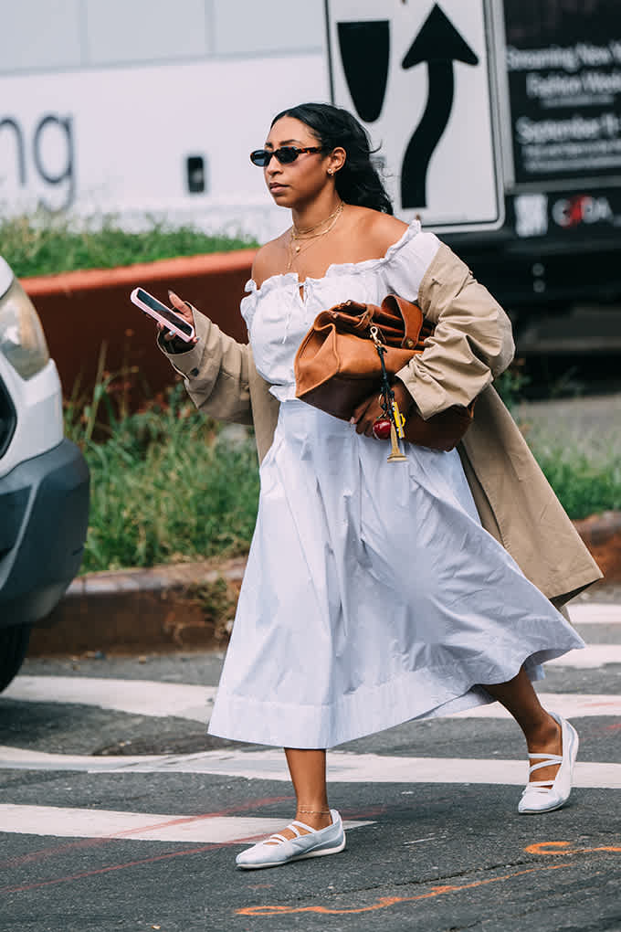 Frau trägt weiße Sneakerina mit elastischen Bändern zu einem luftigen Sommer-Outfit
