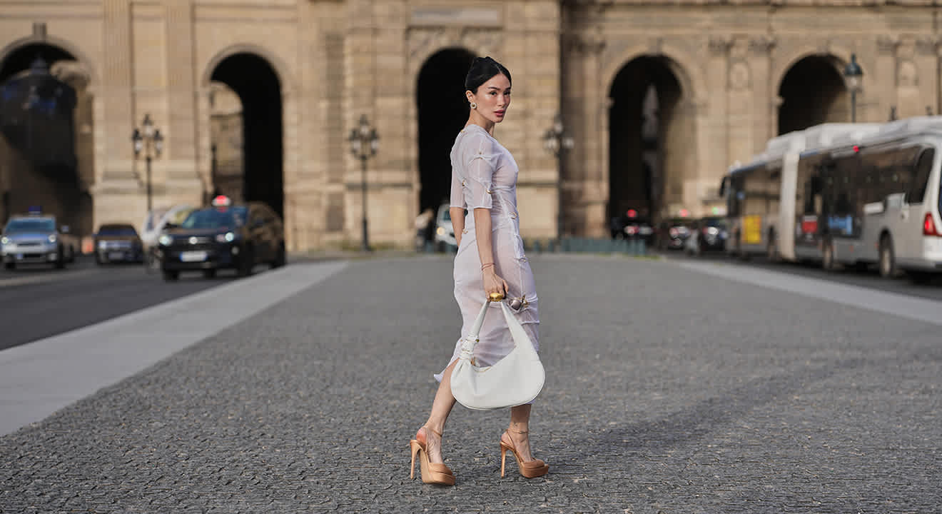 Asiatische Frau in weißem Sheer Dress, auf weitem Platz, mit weißer Shopper Bag
