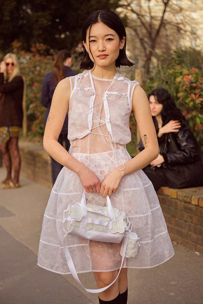 Asiatische Frau in weiß-blassem Sheer Layerin-Look