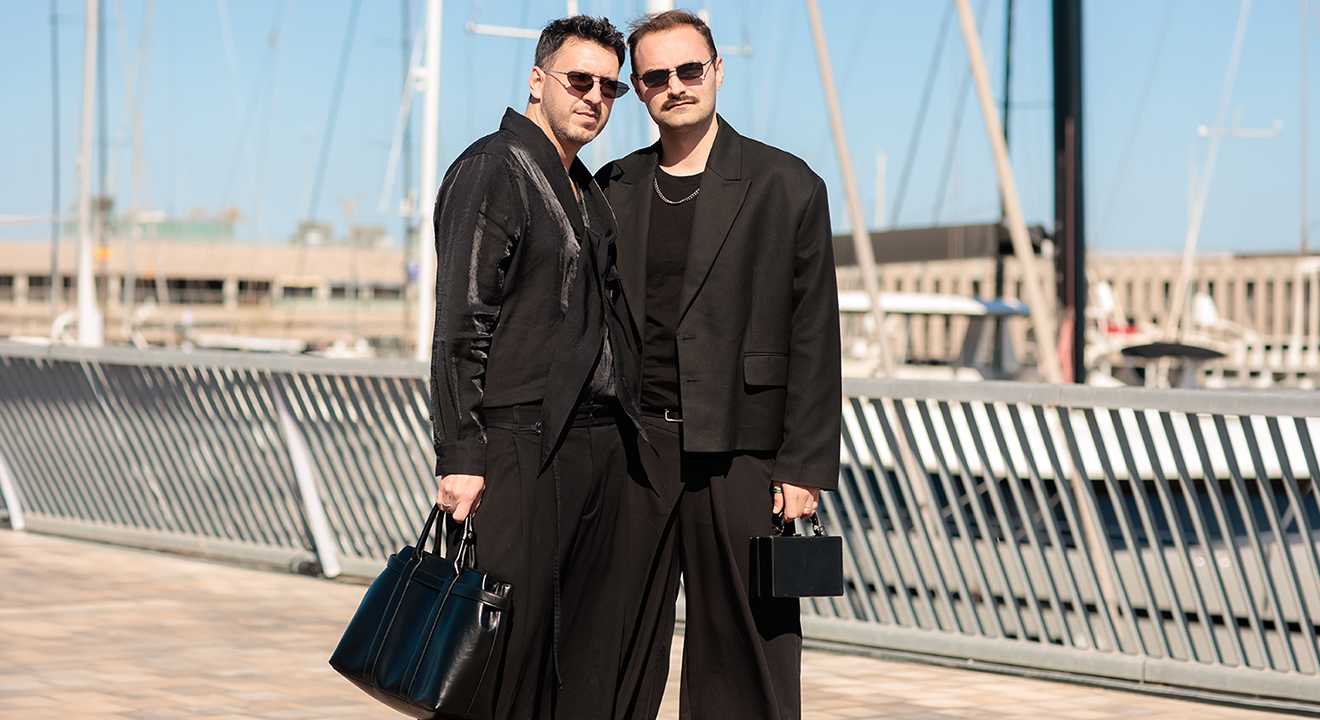 Zwei Männer in Fluid Fashion-Look stehen nebeneinander, tragen Casual Outfits