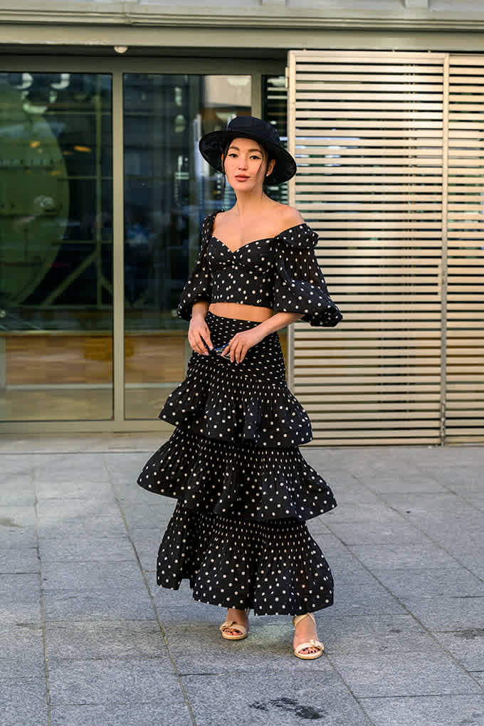 Frau in klug kombiniertem Outfit aus Polka Dot Rock und Oberteil